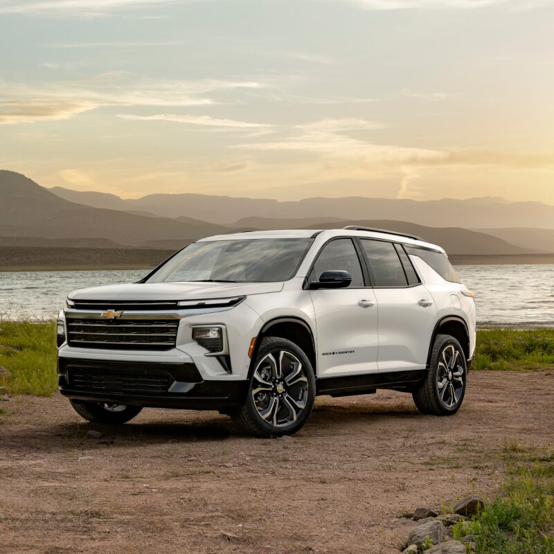 Une Chevrolet Traverse High Country 2027 en Tricoat blanc polaire stationnée au bord du lac.