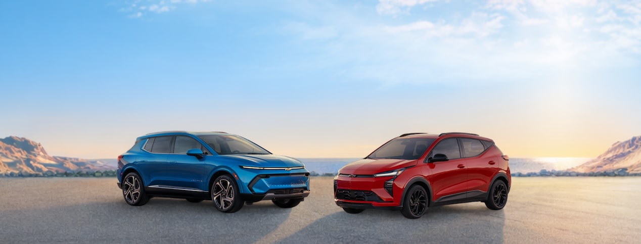 Two Chevrolet EVs parked on a beach.