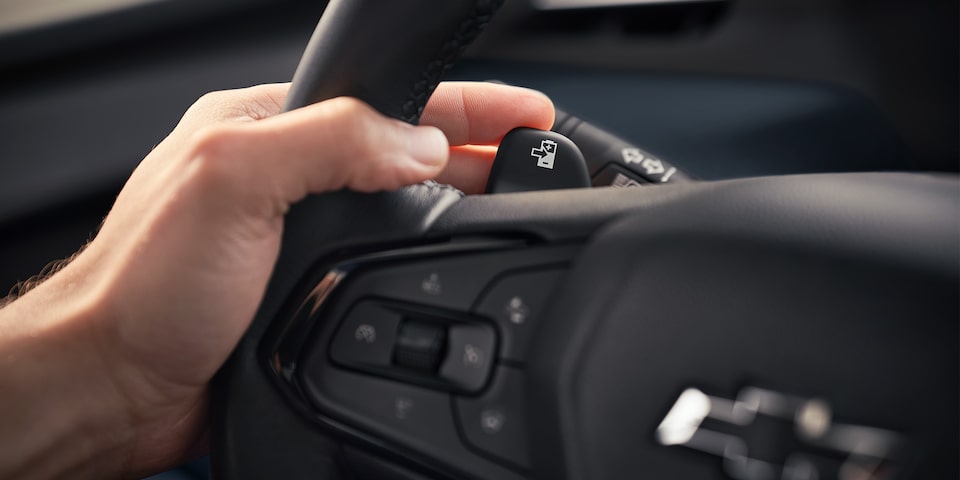 La main du conducteur repose sur le bouton de Regen on Demand du Bolt EUV 2023.