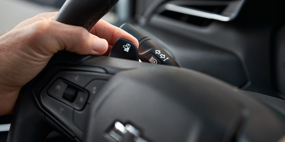 La main du conducteur repose sur le bouton de Regen on Demand de la Bolt EV 2023.