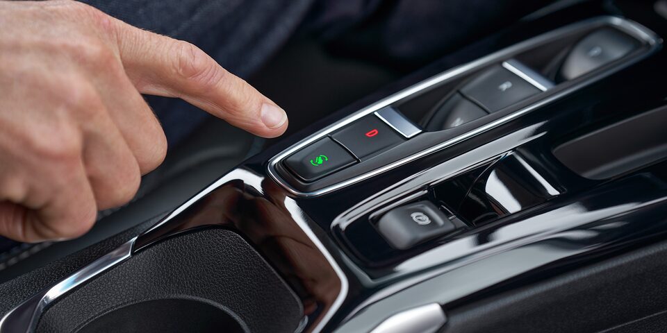 Un doigt se trouve au-dessus du bouton de conduite à une pédale de la Bolt EV 2023.