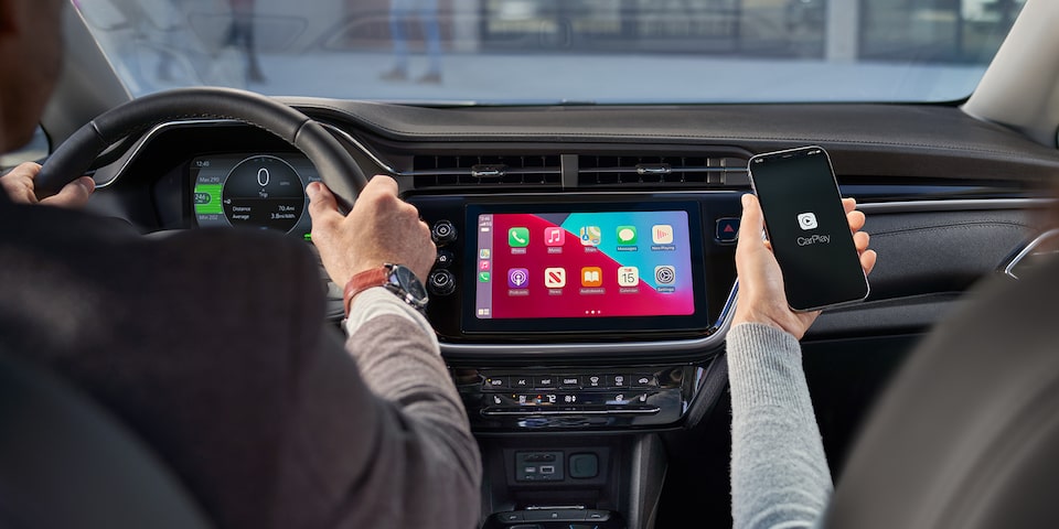 Un couple roule dans une Bolt EV 2023 avec CarPlay d’Apple.