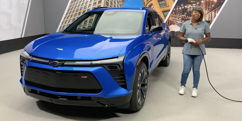 Un employé Chevrolet s’apprête à recharger le Chevrolet Blazer EV dans un bâtiment.