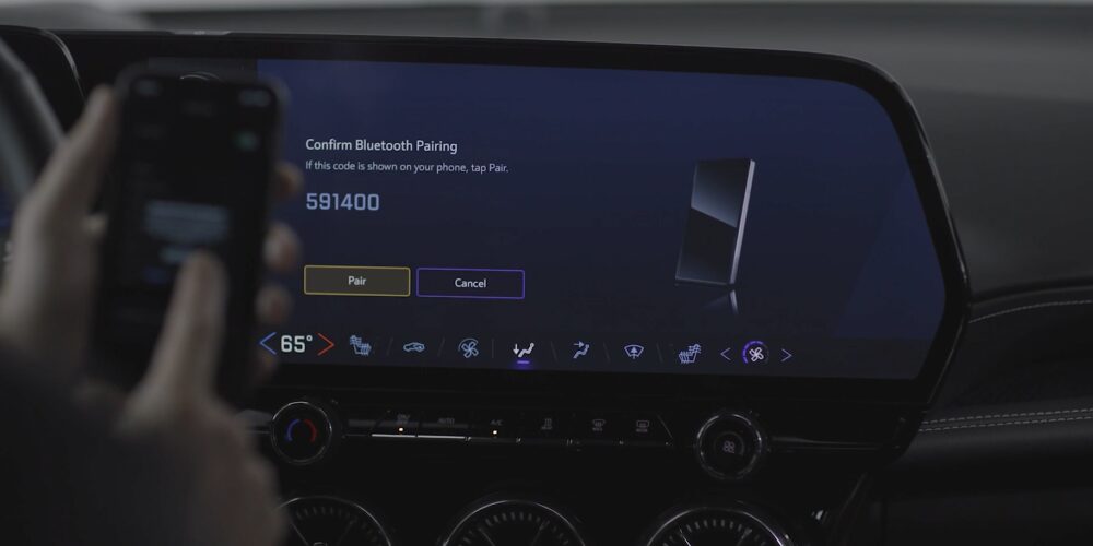 A person using a smartphone to connect with the infotainment screen inside the Chevrolet Blazer EV.