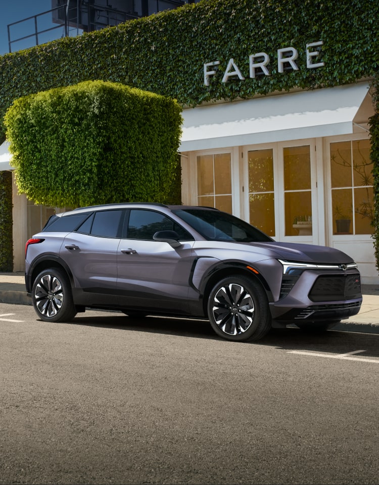 Vue latérale avant du Chevrolet Blazer EV 2025 stationné devant une maison.