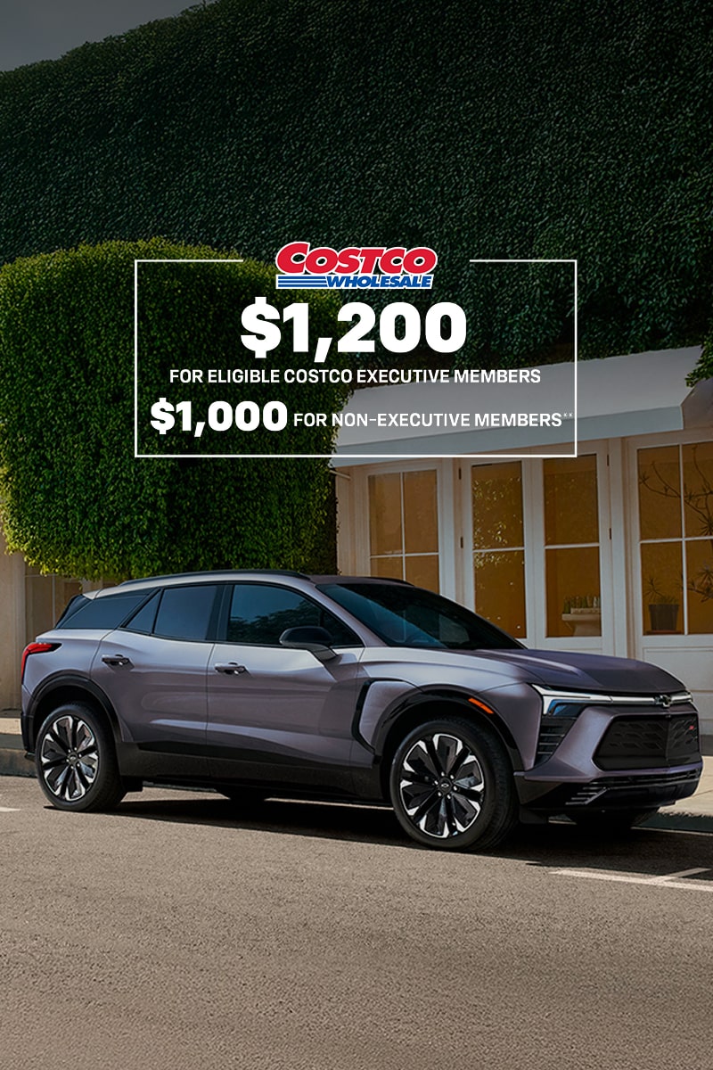 Three quarters view of the 2025 Chevrolet Blazer EV parked outside a house.