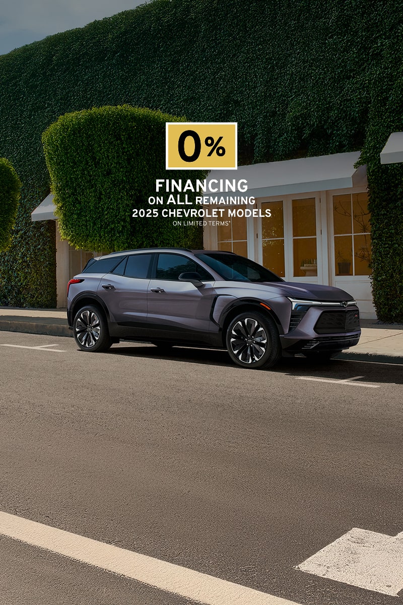 Three quarters view of the 2025 Chevrolet Blazer EV parked outside a house.
