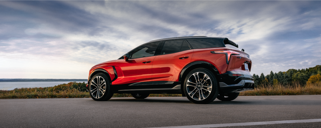 Vue latérale du Chevrolet Blazer EV 2026 stationné près d’un lac.