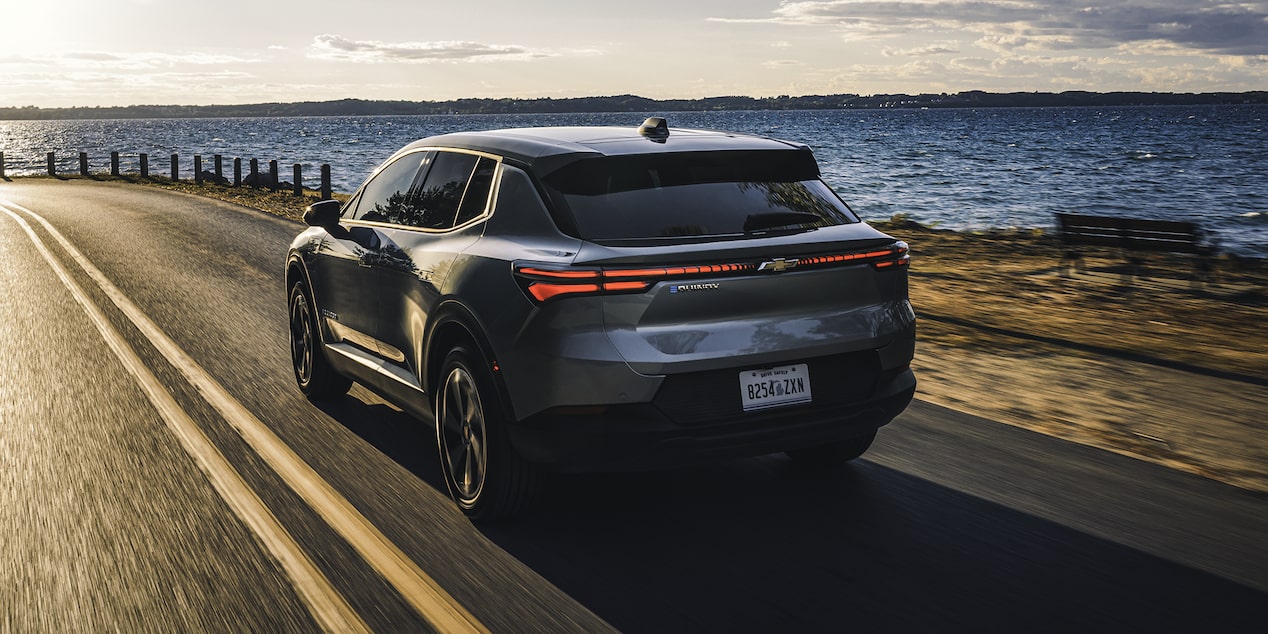 2026 Chevrolet Equinox EV Driving Next to a Lake at Sunset.