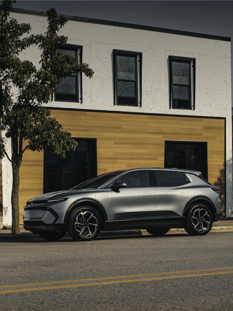 2026 Chevrolet Equinox EV side profile parked in front of a storefront