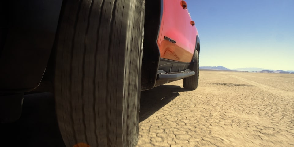 2026 Chevrolet Silverado EV Driving on an Arid Terrain.