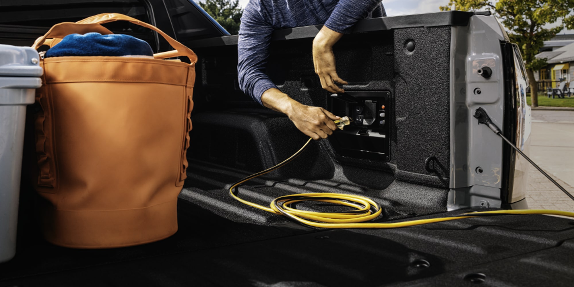 A person plugging an Extension Cord inside the 2026 Chevrolet Silverado EV.
