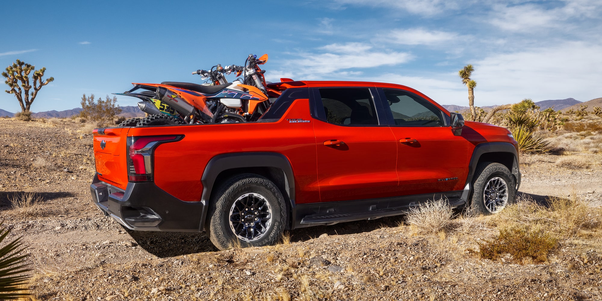 Side View of an the 2026 Chevrolet Silverado EV with a Dirt Bike stowed on the Cargo Bed.