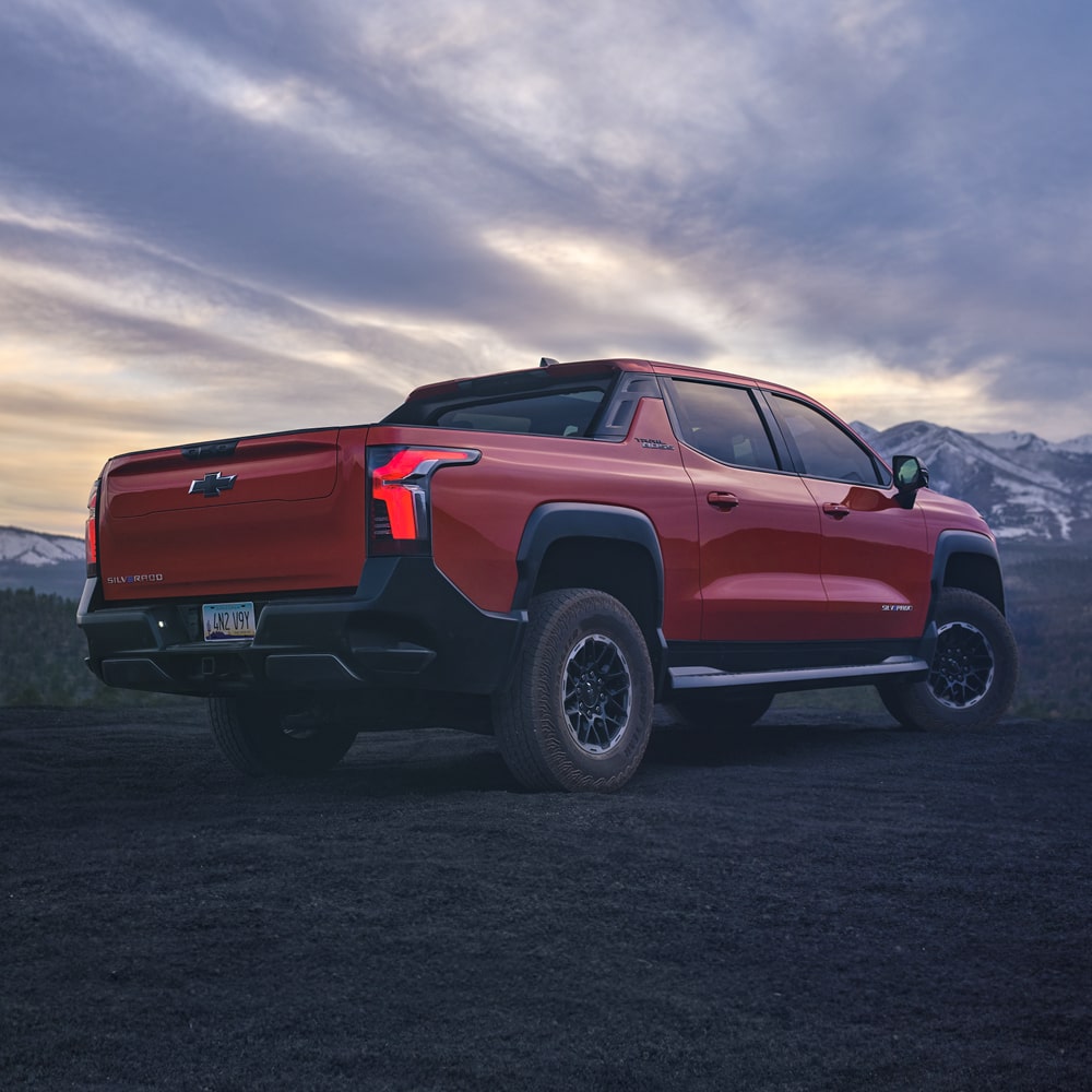 2026 Chevrolet Silverado EV Parked at Dusk with Mountainous Terrain in the Background.