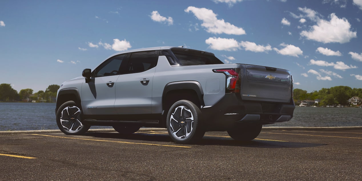Side view of the 2026 Chevrolet Silverado EV in Front of a Body of Water on a Sunny Day.