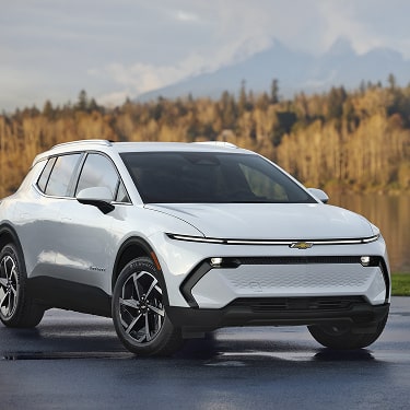 Side Front View of a Silver Equinox EV Parked on Wet Road by the River