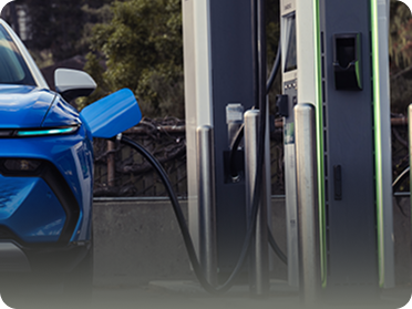 Front View of Chevrolet EV Parked Next to Charging Station