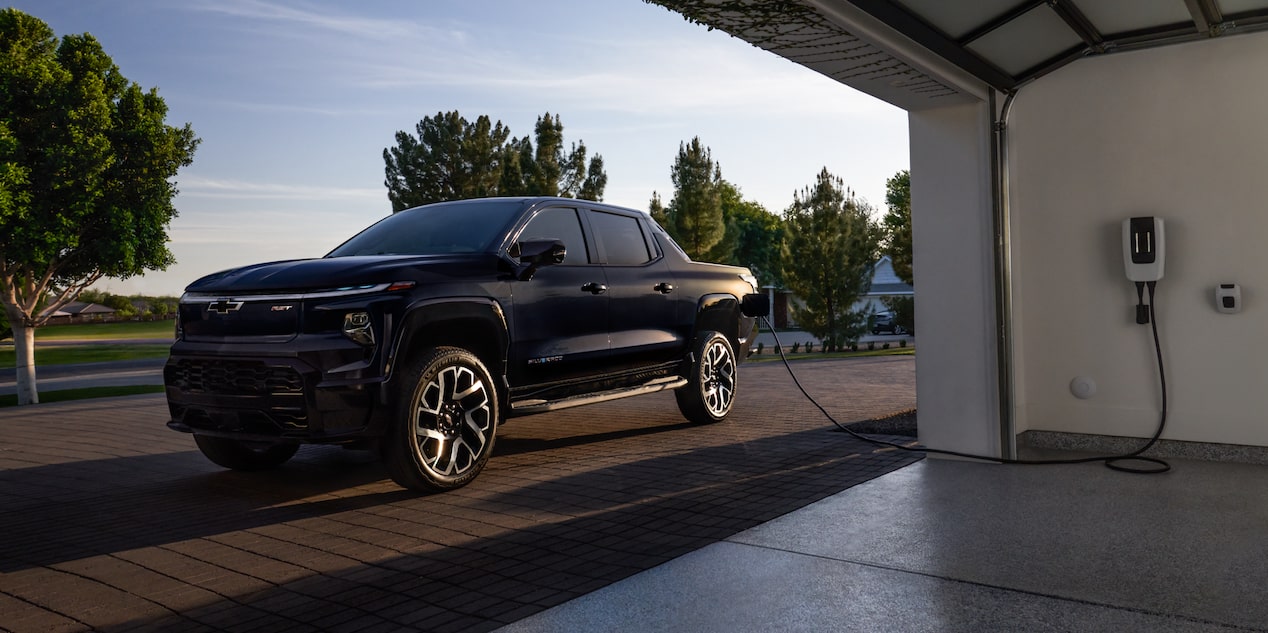 A Chevrolet Silverado EV charging at a home garage.