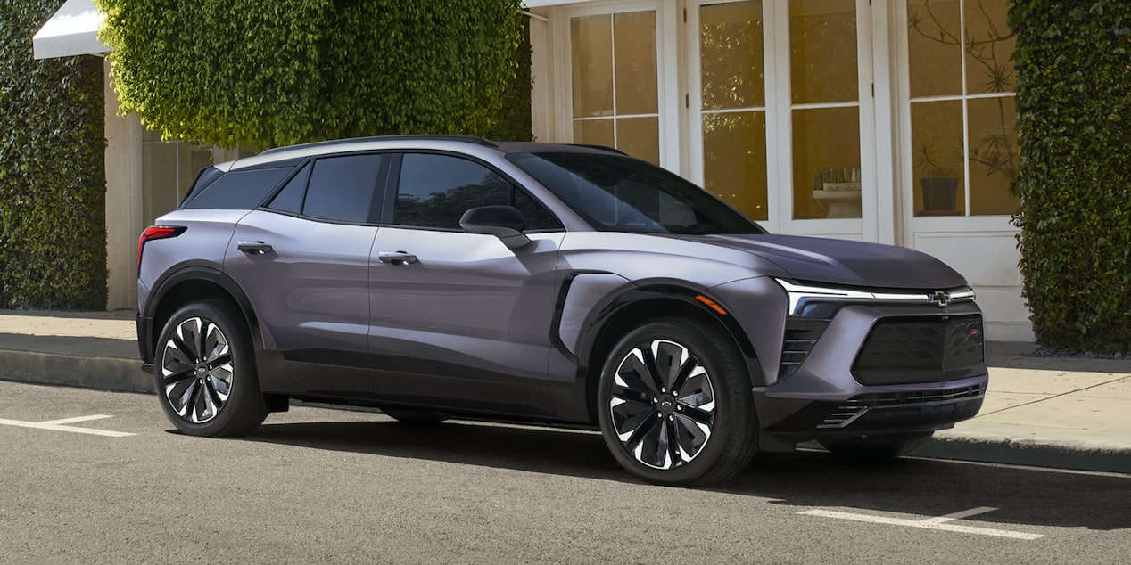Un Chevrolet Blazer EV SS stationné au bord du trottoir devant une boutique.