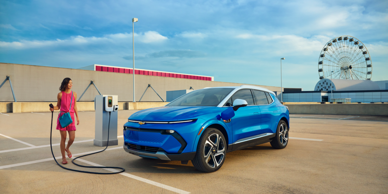 Une femme recharge son Chevrolet Blazer EV à une station de recharge publique.