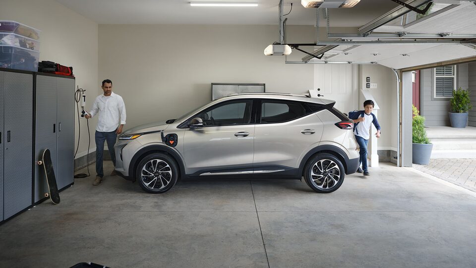 Une personne recharge son VÉ Chevrolet dans son garage.