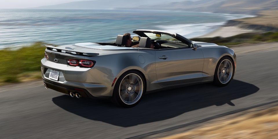 2023 Chevrolet Camaro driving down a shoreside highway.