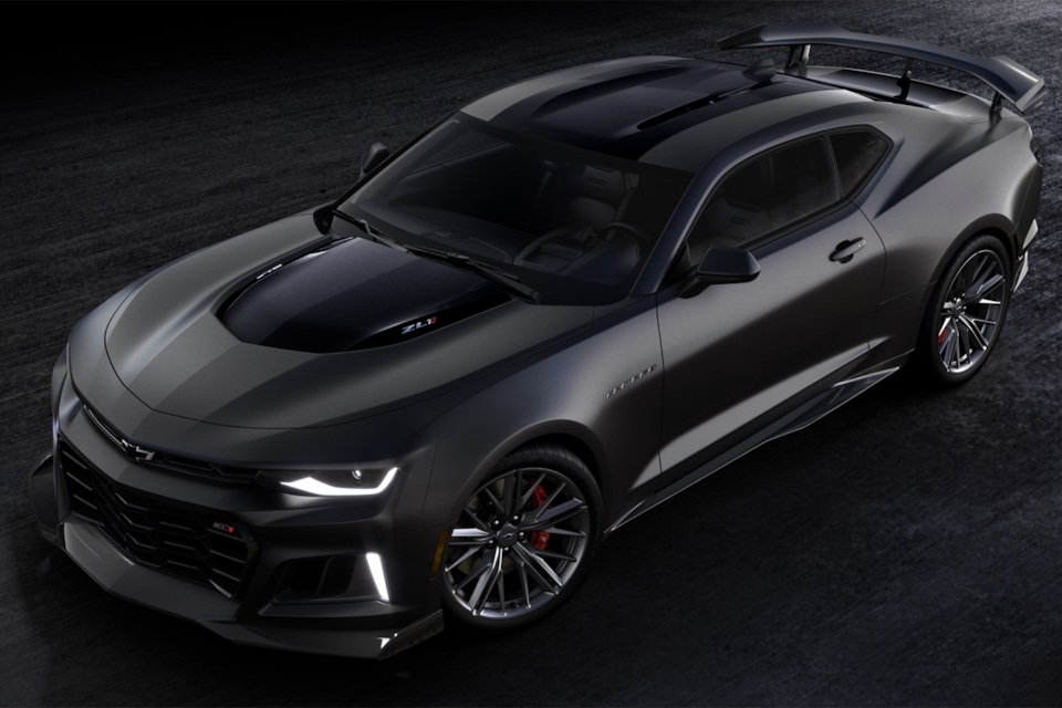 Vue aérienne de la Chevrolet Camaro ZL1 2024 stationnée dans un entrepôt, les phares allumés.