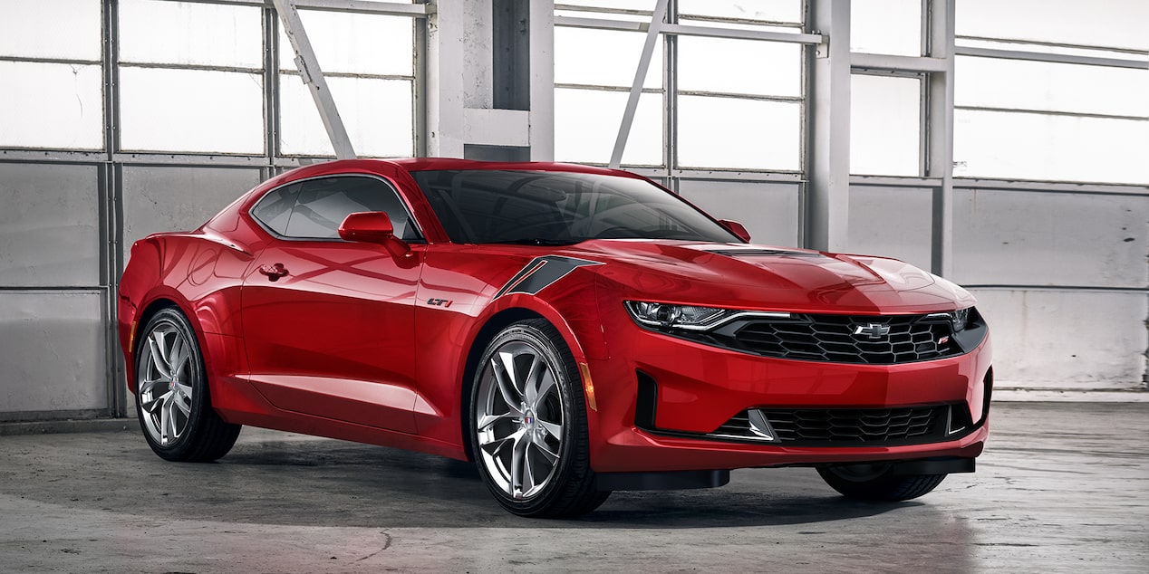 Chevrolet Camaro 2024 rouge stationnée dans un garage pendant la journée.