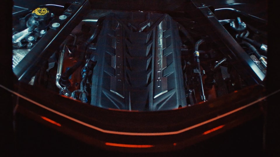 A Chevrolet Corvette E-Ray in a Dark Surrounding with the Hood Opened and the Engine Exposed.