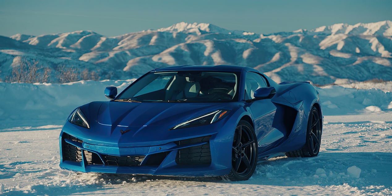 View of a 2025 Blue Chevrolet Corvette E-Ray in an Icy Plain Surrounded by Icy Mountains.