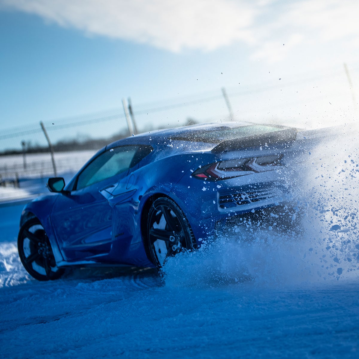 Rear Three Quarters View of the 2026 Chevrolet Corvette E-Ray drifting on a snowy surface.