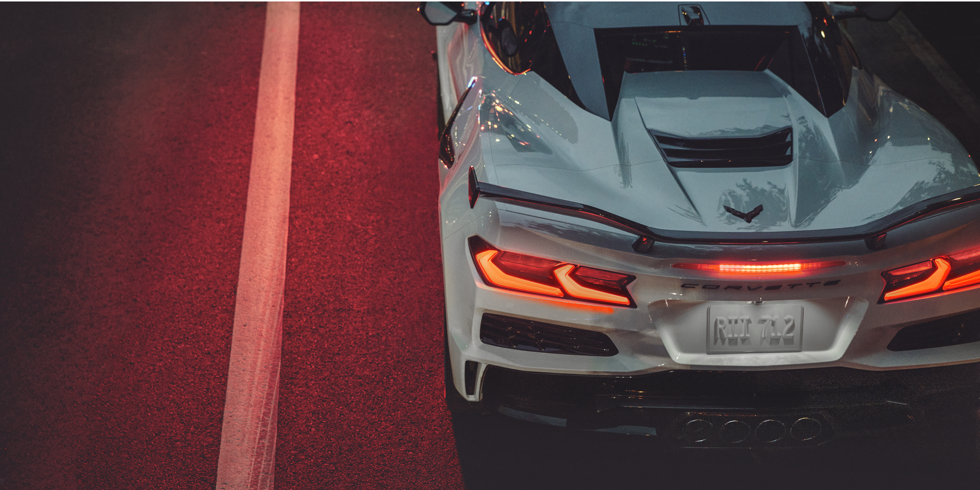 Vue de dessus et de l'arrière de la Chevrolet Corvette Z06 2027 roulant à vive allure de nuit.