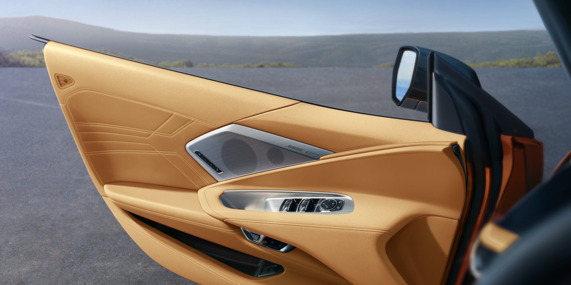 Chevrolet Corvette Z06 2027, portière conducteur ouverte, dévoilant les commandes de portière argentées et un haut-parleur Bose.