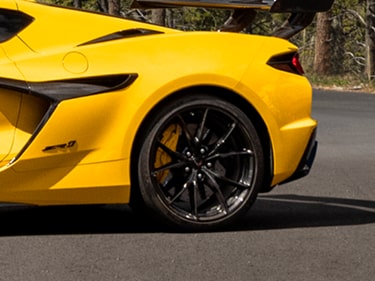 Un gros plan de l’arrière d’une Chevrolet Corvette ZR1 jaune 2027 stationnée sur une route pavée.