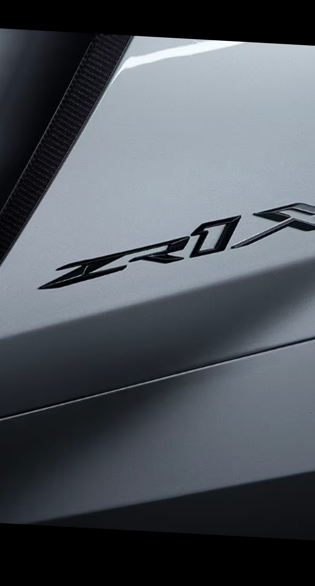 Un gros plan de l’emblème ZR1X sur le panneau arrière de la carrosserie d’une Chevrolet Corvette ZR1X argentée 2027.