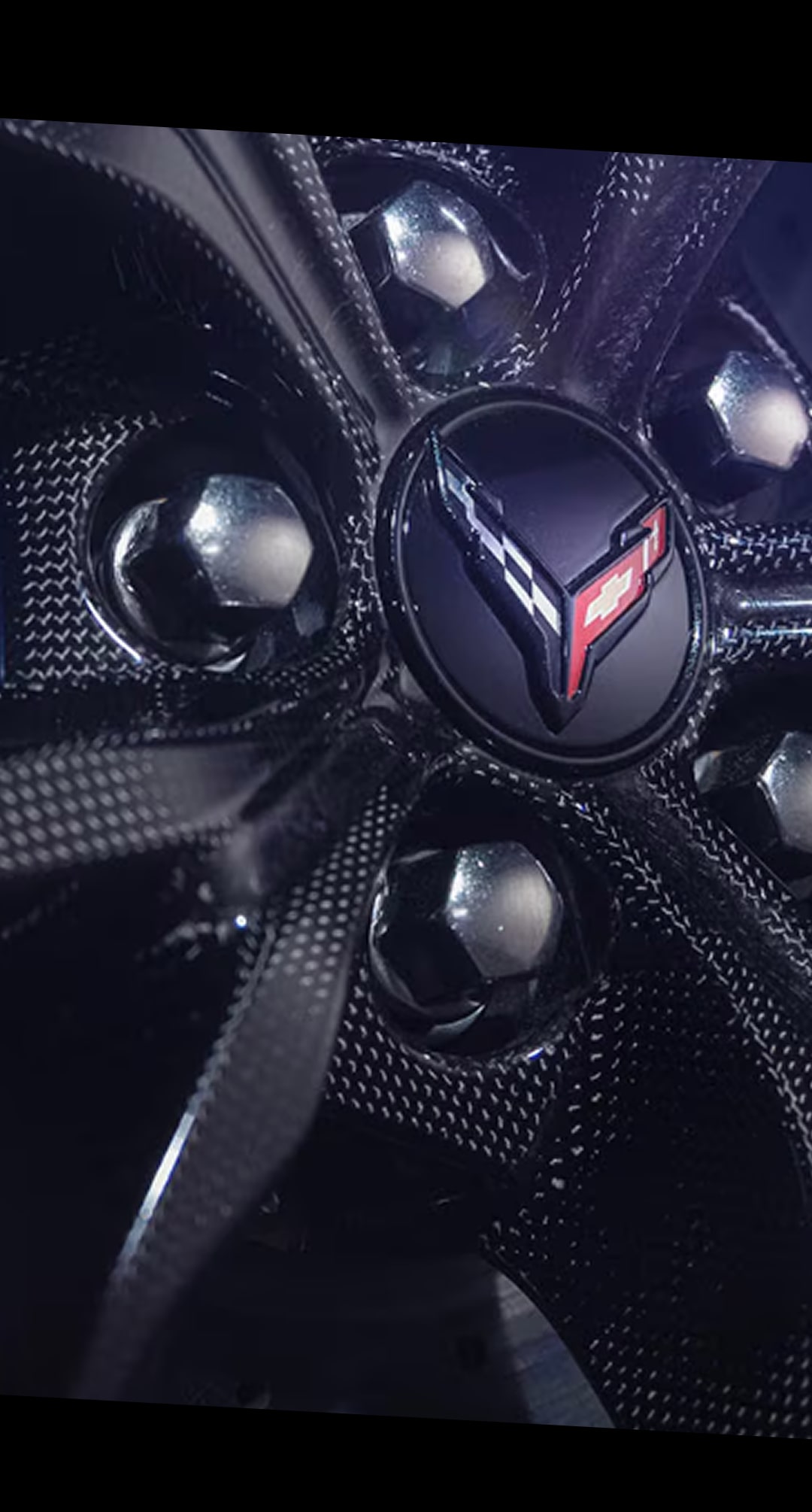 Un gros plan d’un moyeu de roue performant en fibre de carbone noire sur la Chevrolet Corvette ZR1X 2027.