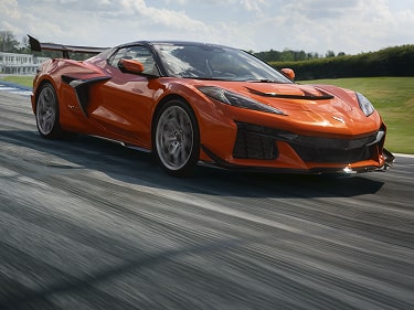Une Chevrolet Corvette ZR1X orange 2027 roulant sur une piste pavée.