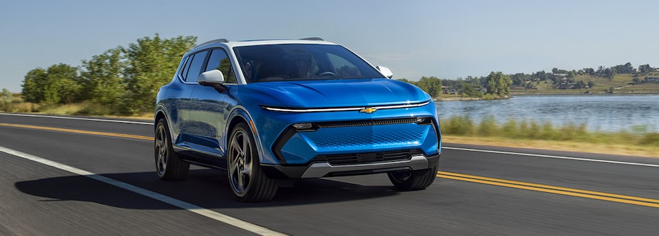 A Chevrolet EV covered by a GM Protection Plan driving alone on the road on a sunny day.