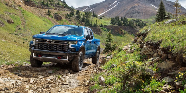 2022 Chevrolet Silverado 1500 driving on rough, inclined terrain.