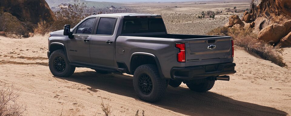 Vue latérale gauche du Chevrolet Silverado HD ZR2 2024 sur un terrain sablonneux.