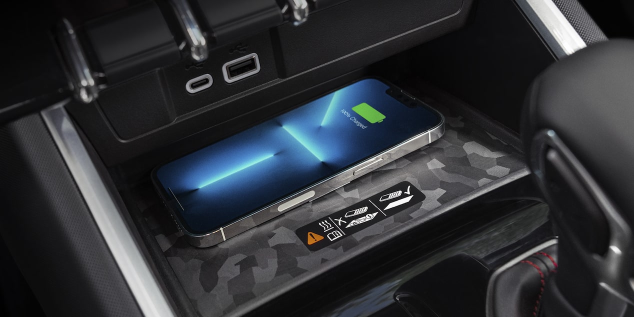 Vue rapprochée d’un iPhone en pleine recharge sur un chargeur sans fil dans un Chevrolet Colorado 2025.