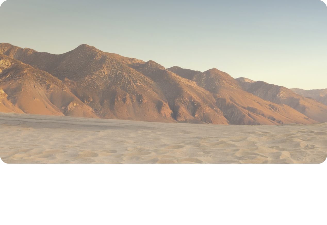 A Scenery of a Desert with Mountains in the Back.