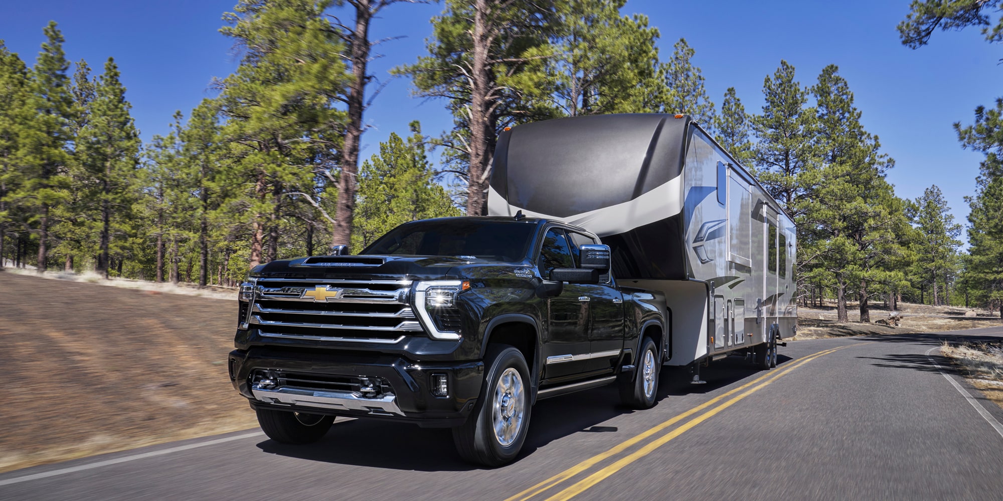 Le Chevrolet Silverado HD 2026 qui tire une remorque sur la route.