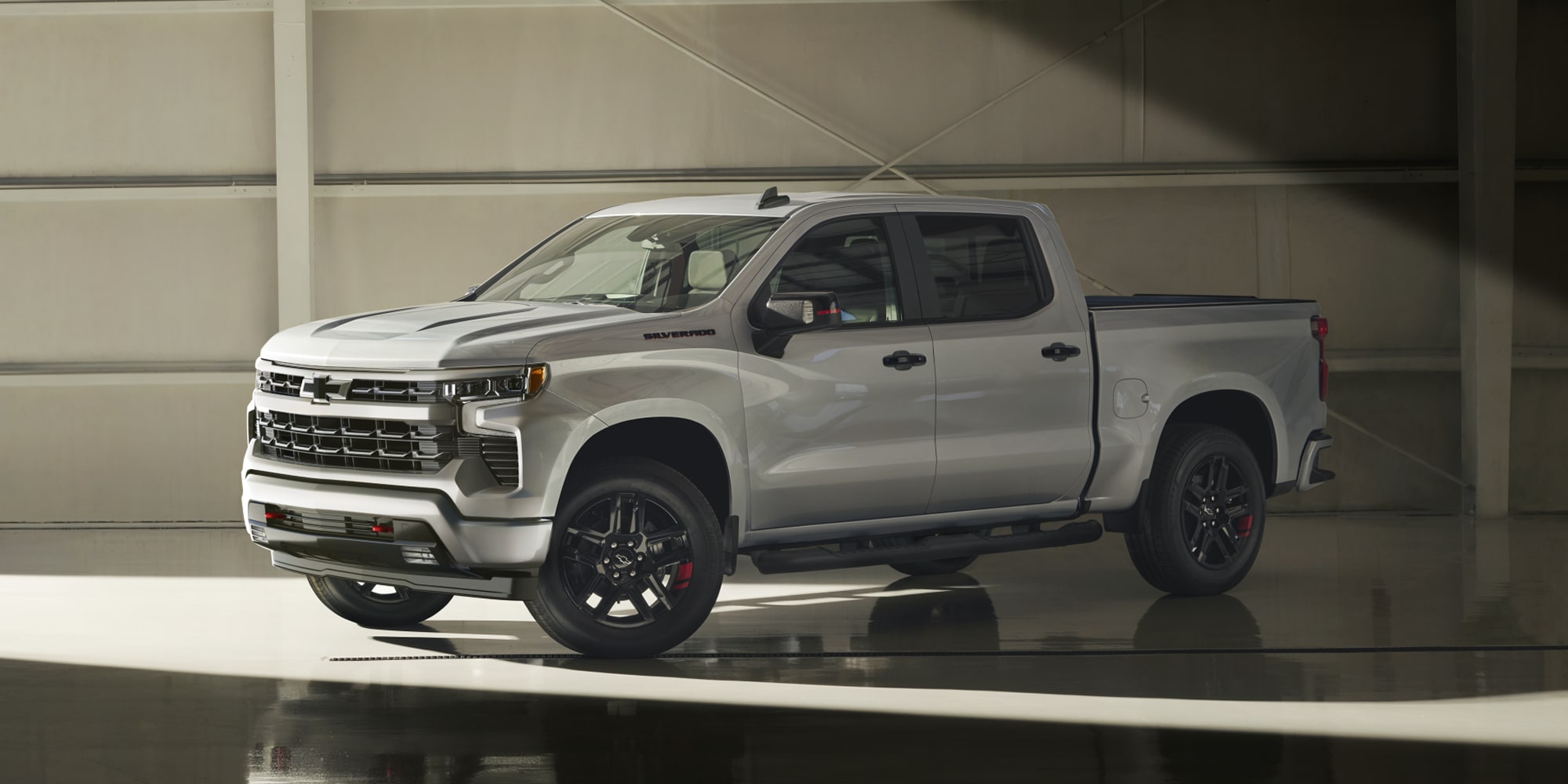 Profil latéral du Chevrolet Silverado 2026 stationné dans un entrepôt 