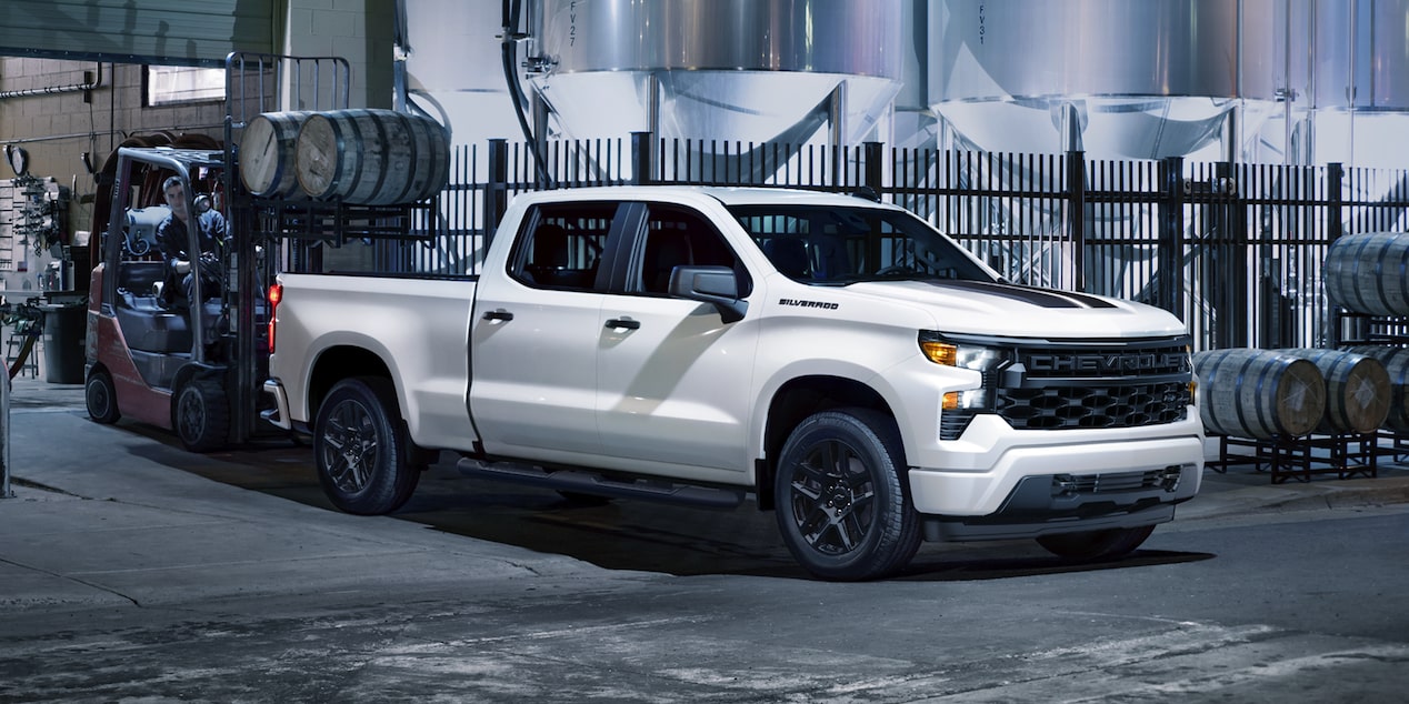 Vue latérale du Chevrolet Silverado LD 2026 stationné dans un bâtiment.
