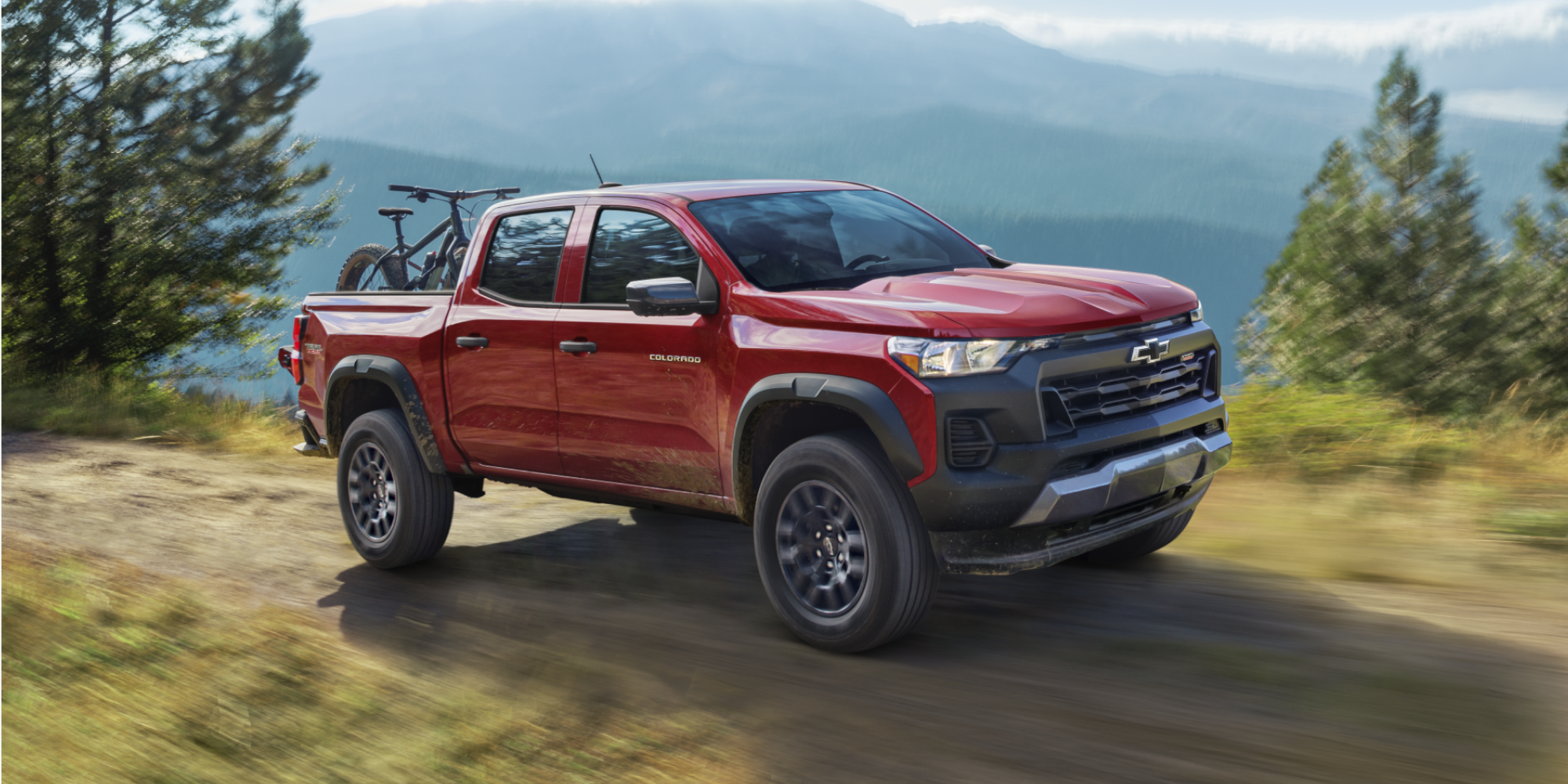 Chevrolet Colorado Trail Boss Driving in the Mountains with Bicycles Stored in the Truck Bed.