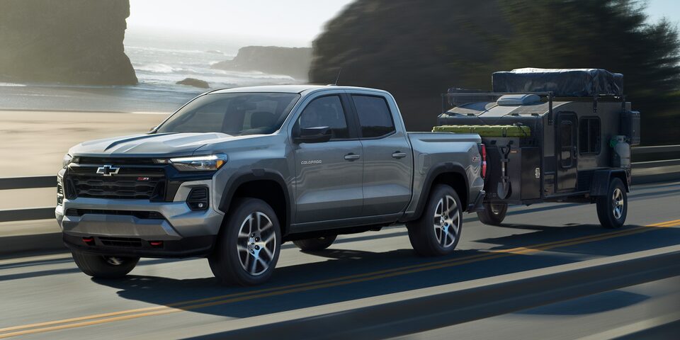 The 2023 Colorado Towing a Small Trailer on an Empty Coastal Road.
