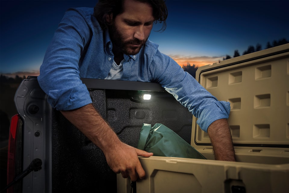 A Man Grabbing Tools from the Truck Bed of His 2023 Colorado.