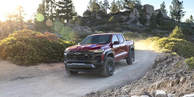 Exterior front driver side view of the 2023 Colorado driving down a winding road.