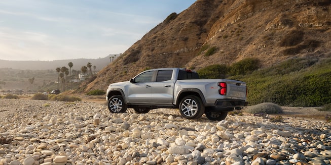Exterior driver side view of the 2023 Chevrolet Colorado on rocky terrain.